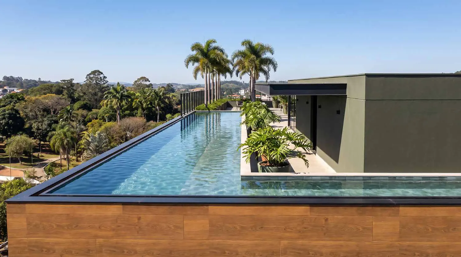 Piscina com raia no rooftop, com vista para as árvores